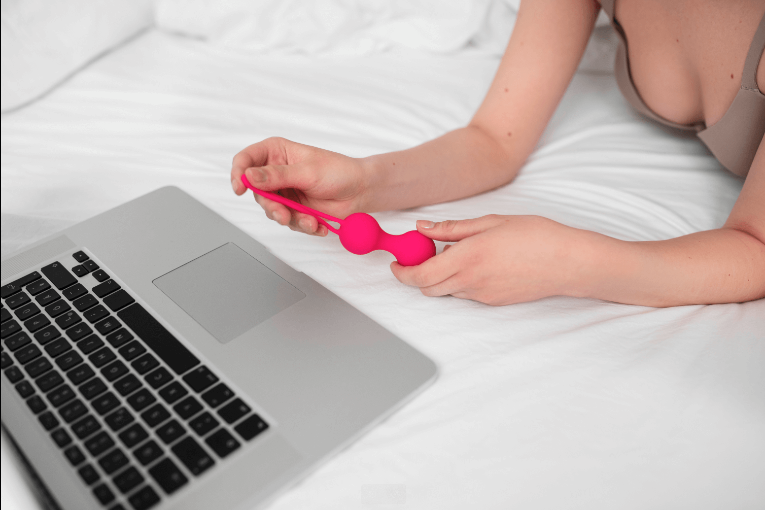 A woman in front of her laptop with a sextoy